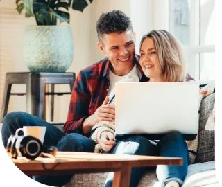 Couple doing insurance online together Couple doing their insurance on couch together